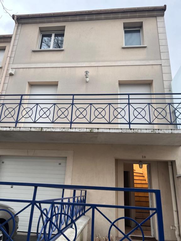 a house with a balcony and a gate at Grande Maison proche Paris 10 12 personnes in Bagnolet