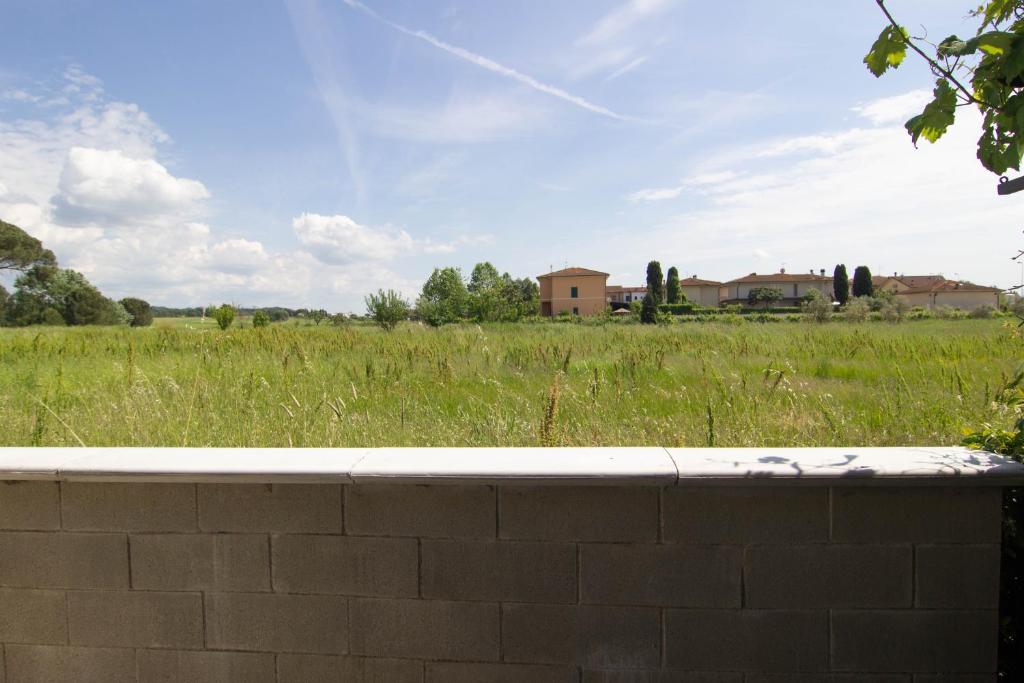 een stenen muur met een veld op de achtergrond bij Daniel's House in Pontedera