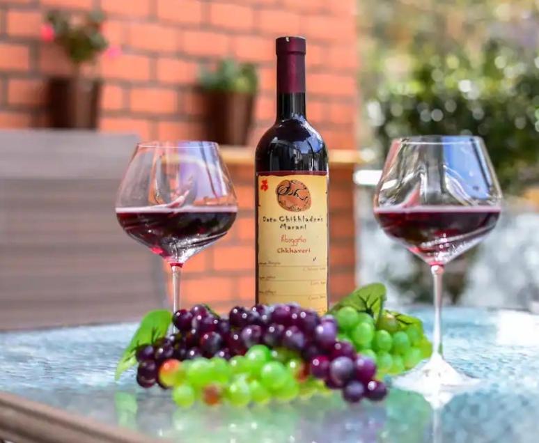 dos copas de vino y un racimo de uvas en Salve rooms2 tabidze, en Tiflis