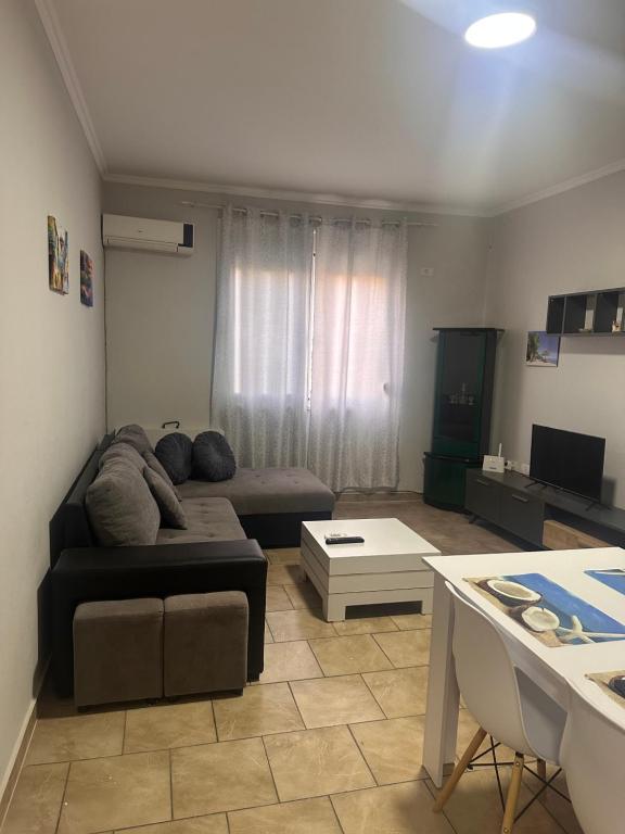 a living room with a couch and a table at Adrian Apartment in Orikum