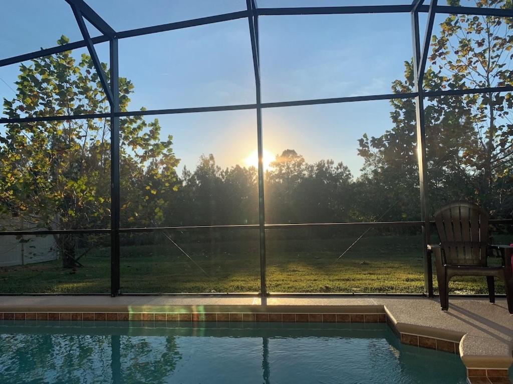 a swimming pool with a view of the sun through a window at Sruthan Kerith in Davenport