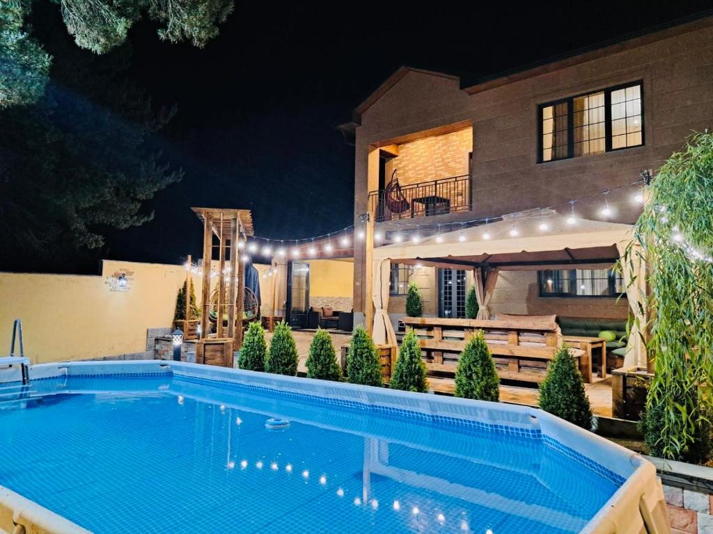 萨克德佐尔镇Capital Tsaghkadzor的一座大型游泳池,在晚上在房子前面