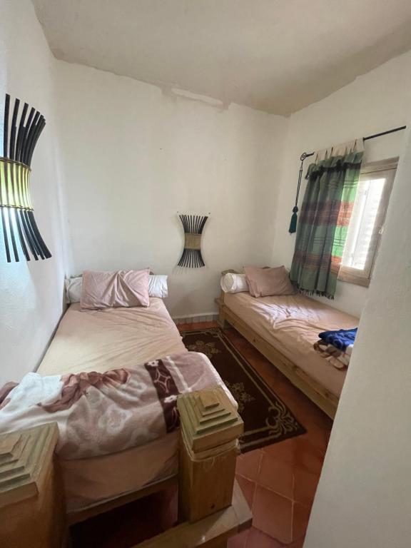 索维拉شقة امام البحر دات اطلالة جميلة的有两张床和一扇窗户的房间