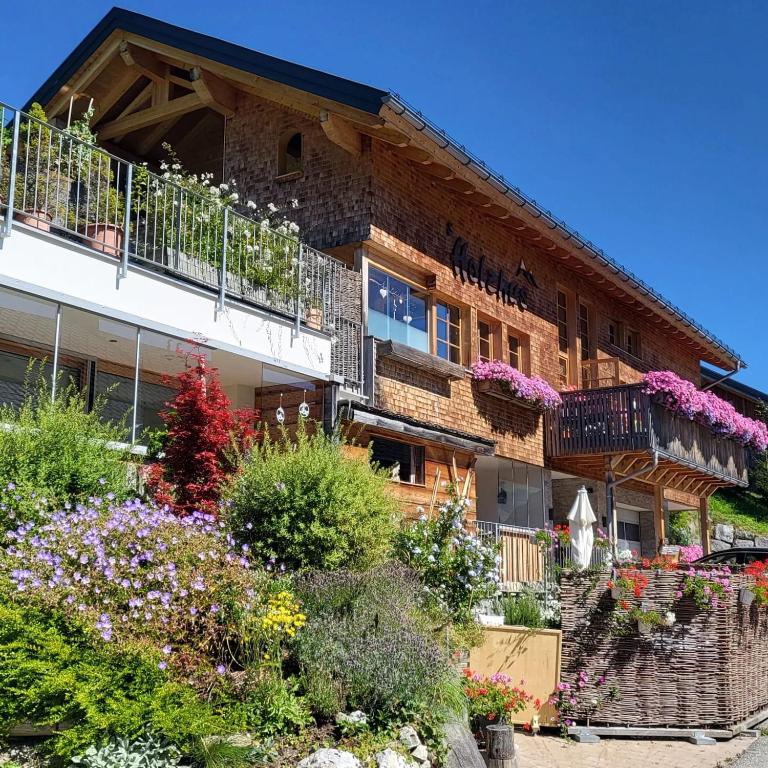 an apartment building with flowers on the balconies at Damülser Holzhus in Damuls