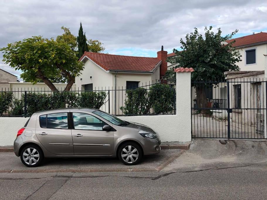 サン・ボネ・ド・ミュールにあるVilla - Saint Bonnet de Mureのフェンスの前に駐車された小さな銀色の車