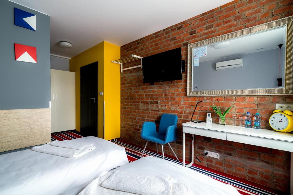 a bedroom with a bed and a brick wall at Tamada in Ozorków