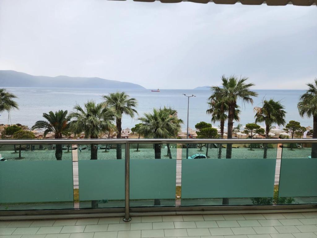 d'un balcon offrant une vue sur l'océan et les palmiers. dans l'établissement JRL Residence, à Vlorë