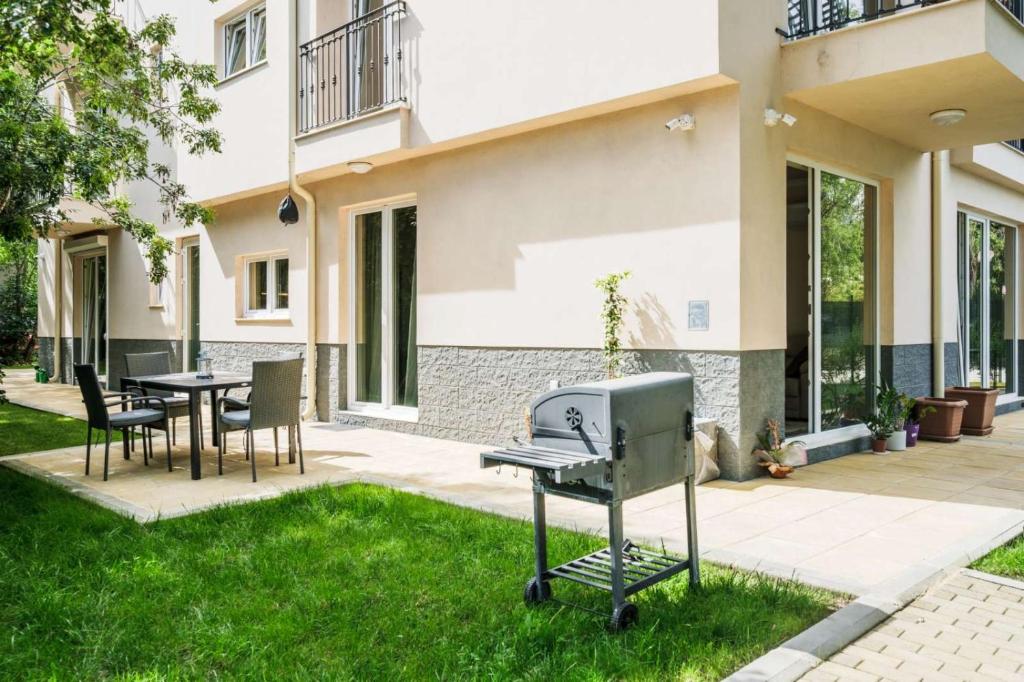 a barbecue grill in the yard of a house at Garden Apartment Fichoza 2 - 80m from the sea in Varna City