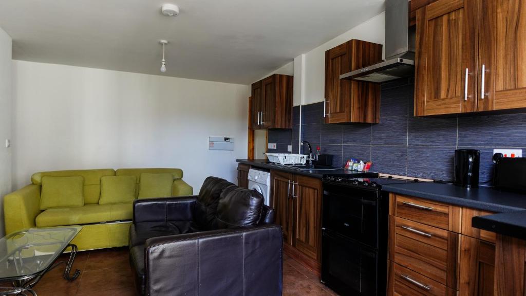 Una cocina con un sofá verde en una habitación. en The No 10, en Mánchester