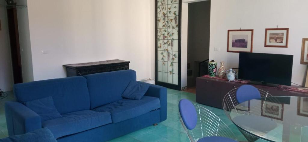 een woonkamer met een blauwe bank en een glazen tafel bij Ca' da Mariolina in Carloforte