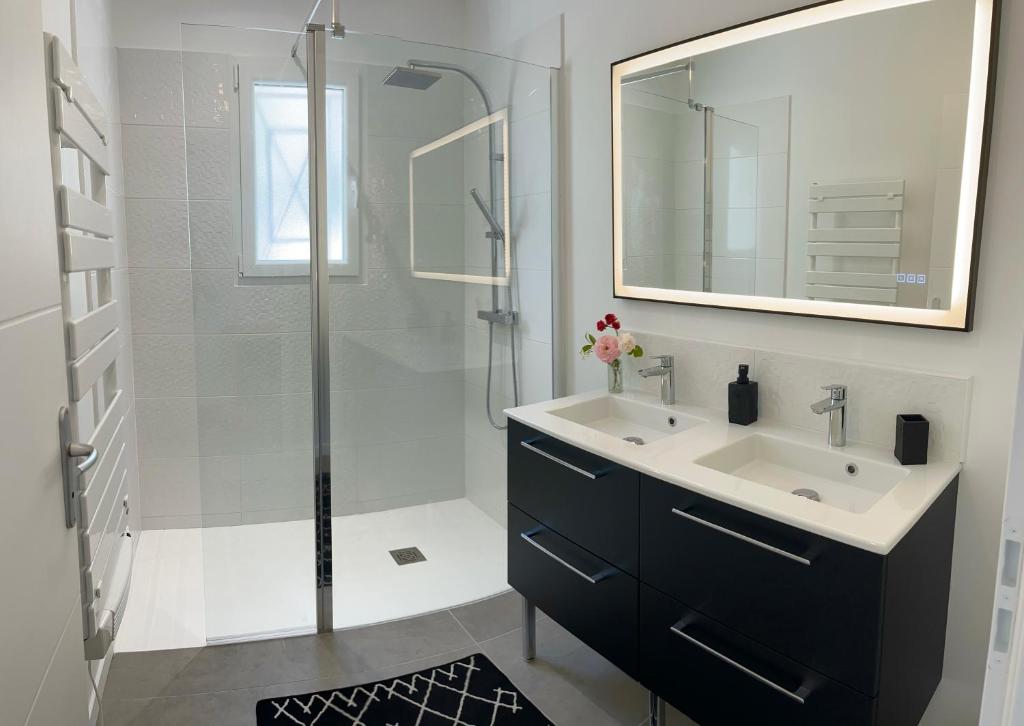a bathroom with a sink and a shower with a mirror at Villa moderne vue exceptionnelle et SPA in Villetoureix