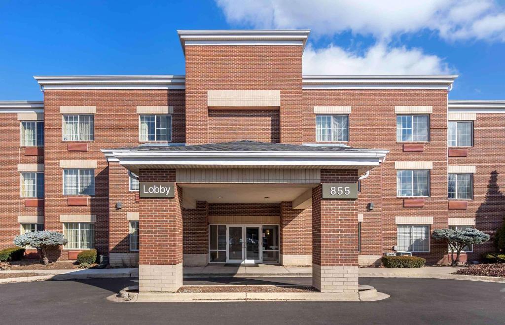 a large red brick building with the front entrance at Extended Stay America Select Suites - Chicago - Westmont - Oak Brook in Westmont