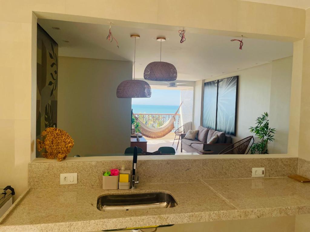 um balcão de cozinha com um lavatório e um espelho em Ap centro de Guarapari com as melhores vistas!!! em Guarapari