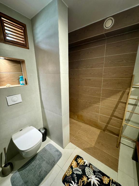 a bathroom with a toilet and a shower at Escapade Panoramique Appt prestige vue mer in Fort-de-France