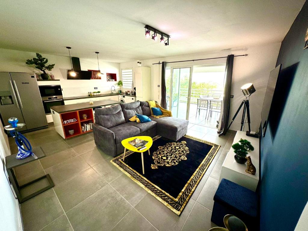 a living room with a couch and a table at Escapade Panoramique Appt prestige vue mer in Fort-de-France