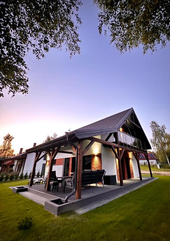 a pavilion with tables and benches in a field at GrandBytyń House in Nakielno