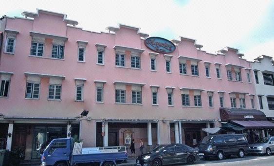 a pink building with a clock on top of it at Amrise Hotel in Singapore