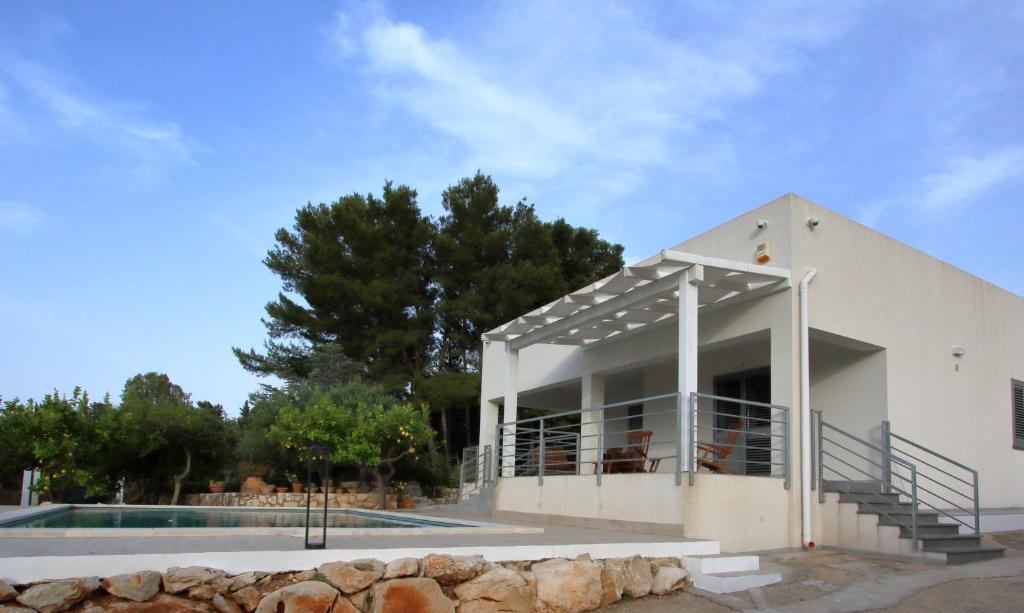 a white house with a pool in front of it at villa grecale in Castellammare del Golfo