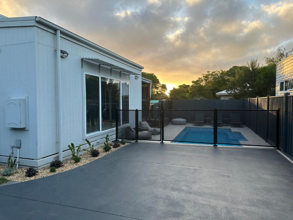 a backyard with a fence and a swimming pool at Absolutely Beach in Cowes