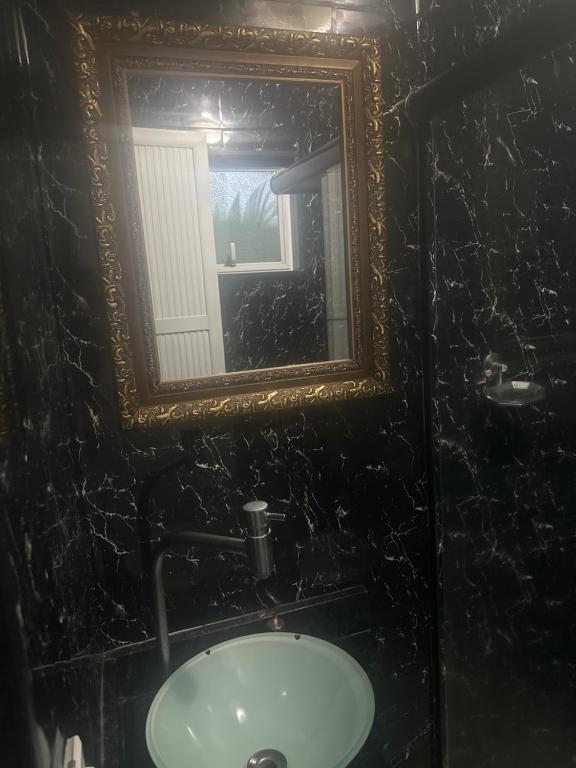 a bathroom with a mirror and a sink at Hotel Pousada Irmaos Freyhardt in Rio de Janeiro