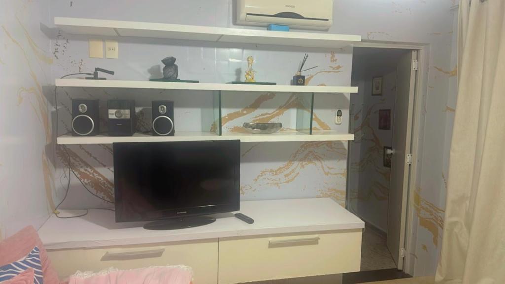 a tv sitting on a shelf in a room at Hotel Pousada Irmaos Freyhardt in Rio de Janeiro
