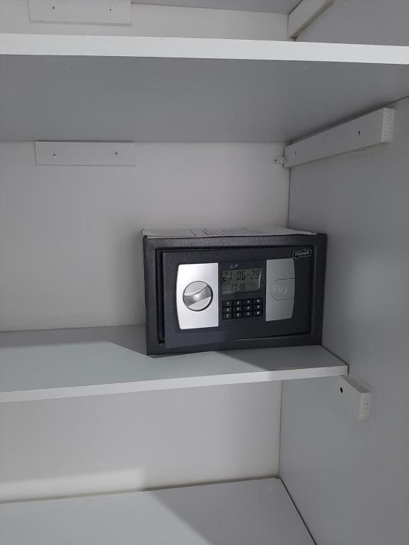a microwave sitting on a shelf in a closet at aparta estudio en envigado bien dotado y bien ubicado in Envigado