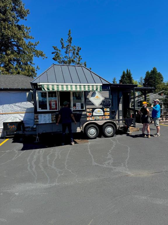 a food truck with people standing in front of it at Cascade Lodge in Bend