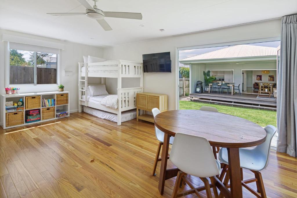 a living room with a table and chairs and a bedroom at Moffat Beach Entertainer with Kids Retreat & Walk to Beach in Caloundra