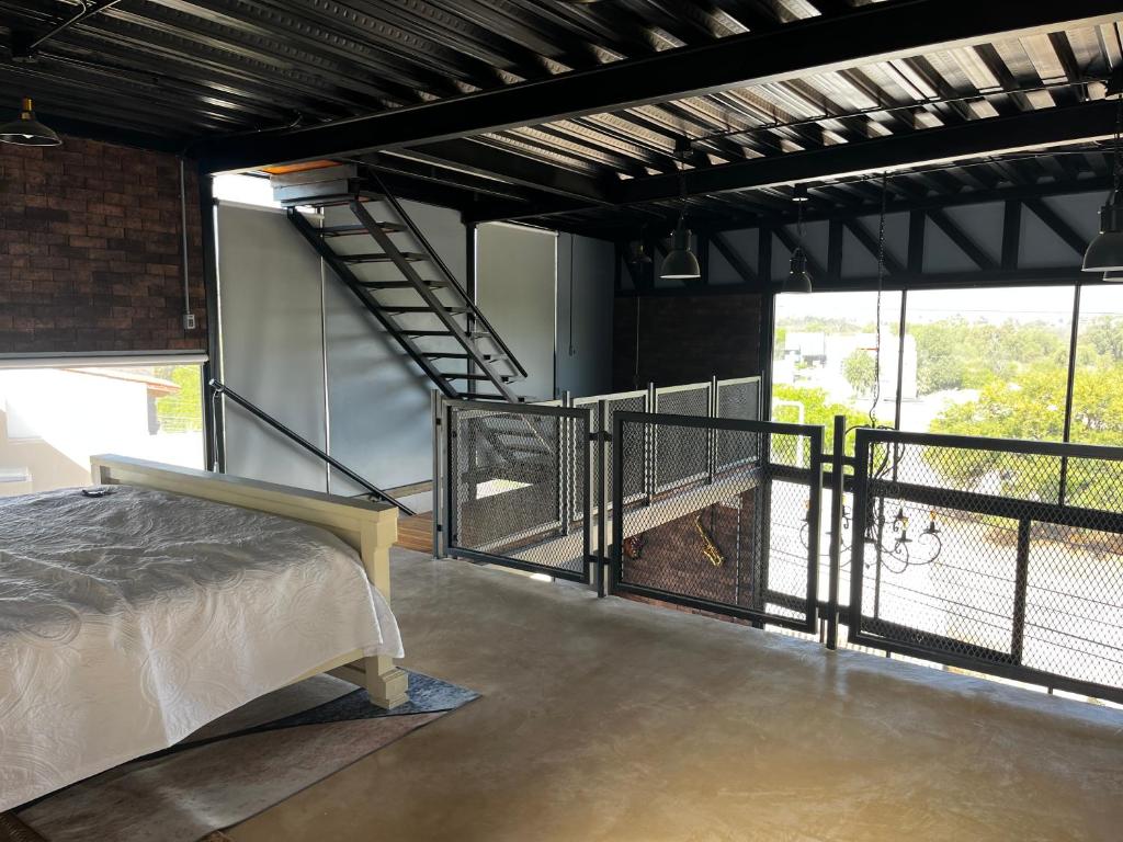 Habitación con cama y balcón con ventanas. en LoftenTequis, en Tequisquiapan