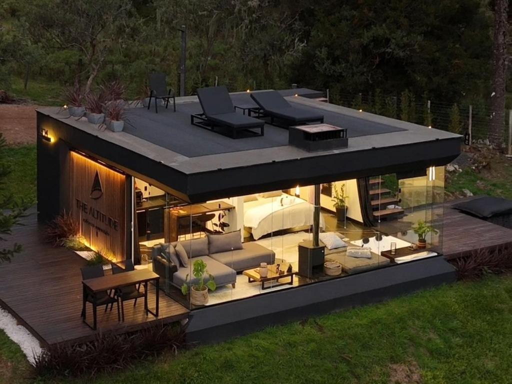a house with a deck with a lot of furniture at The Altitude Cabana 1374-Black in Urubici