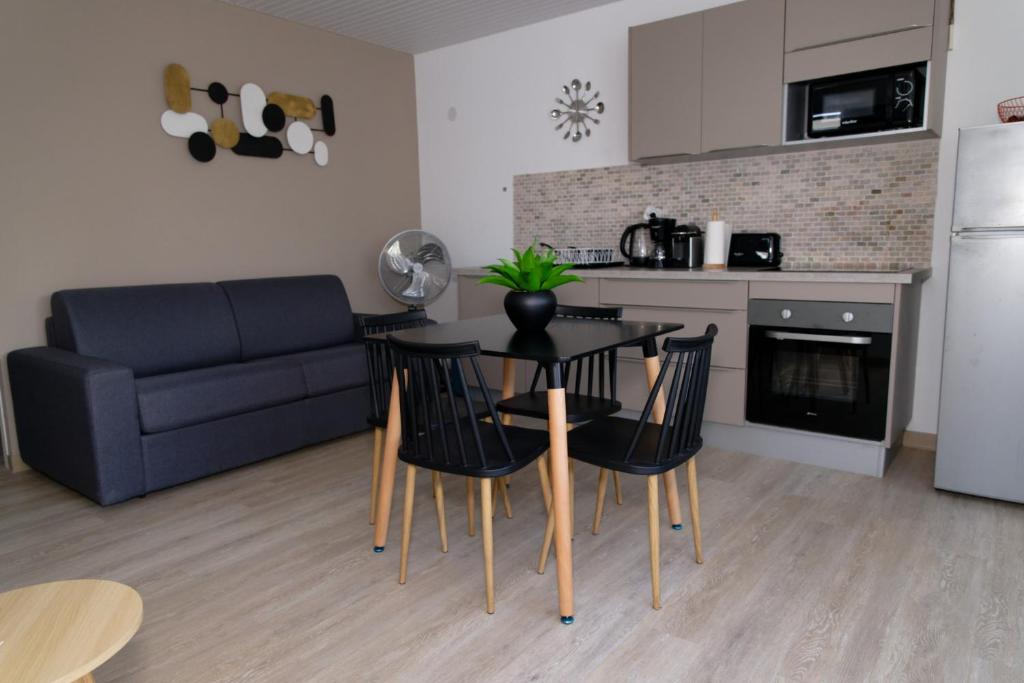 a living room with a table and chairs and a couch at LA DESIRADE SAINTE-ANNE in Sainte-Anne