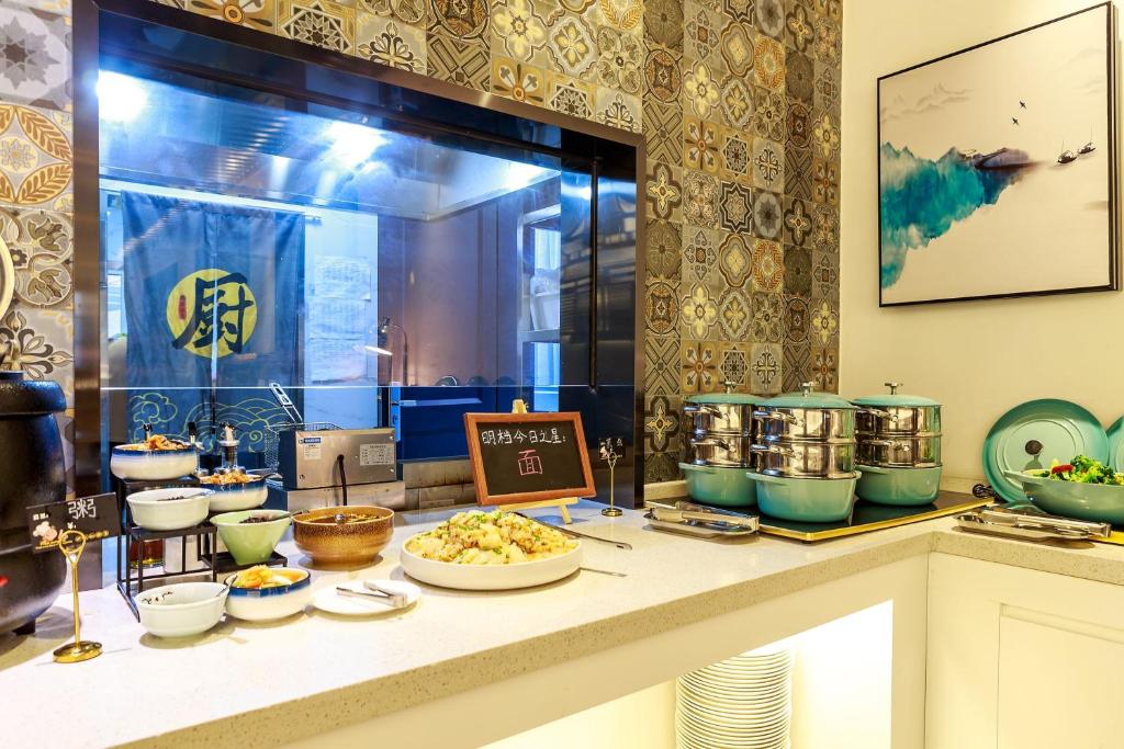 a buffet of food on a counter in a room at Nost algia S Hotel Near Chengdu Kuanzhai Alley - People's Park, Chengdu Panda Base, 10 minutes walk to subway , Free laundry, English communication well, Free coffee,Free travel advice in Chengdu