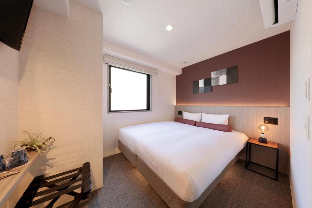 Postel nebo postele na pokoji v ubytování Doutonbori Crystal Hotel IV