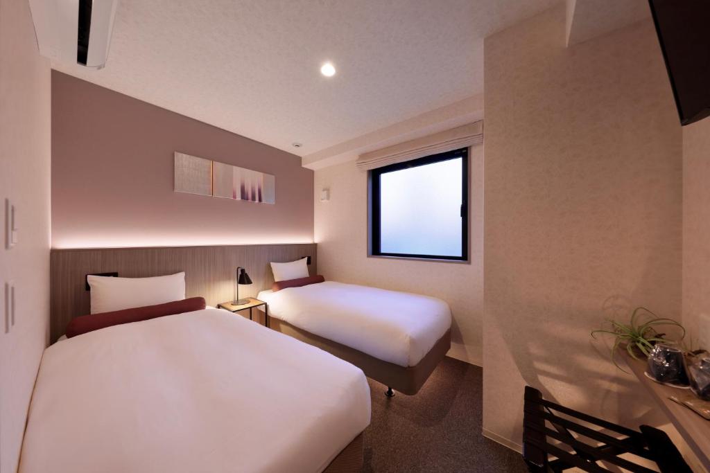 Postel nebo postele na pokoji v ubytování Doutonbori Crystal Hotel IV