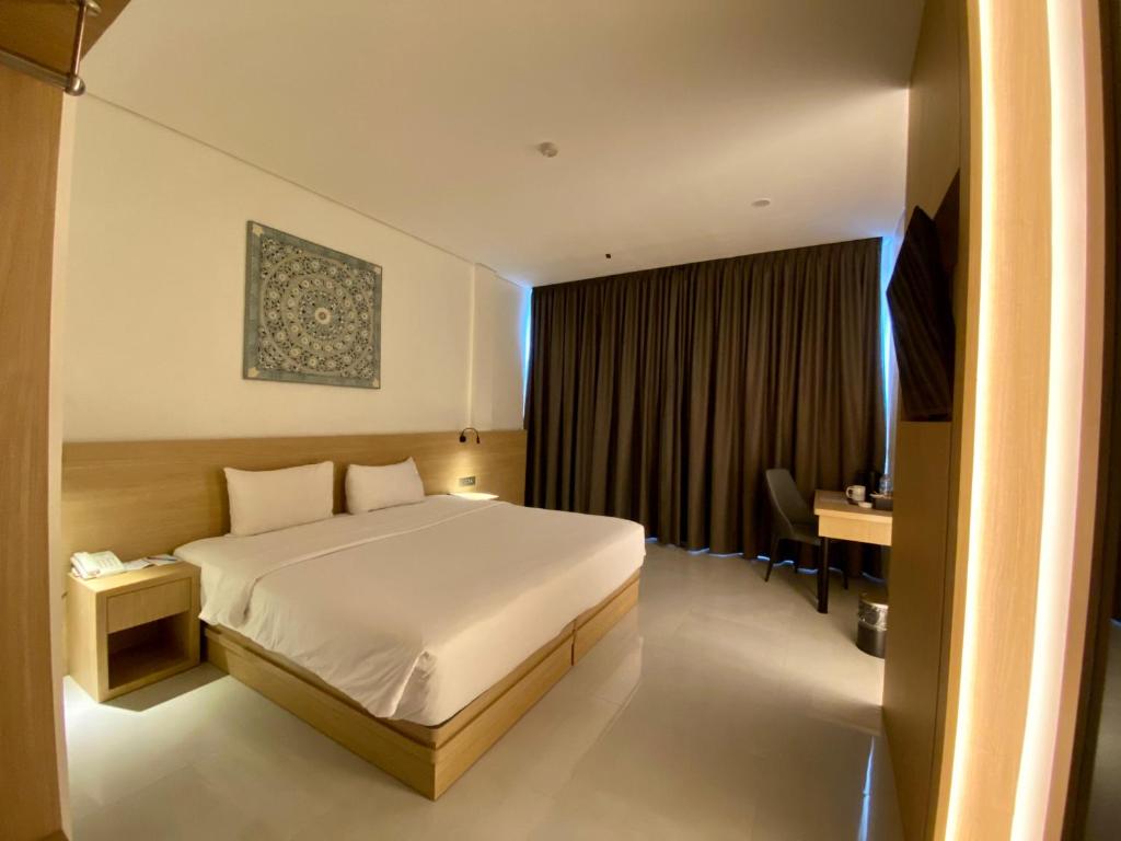 Postel nebo postele na pokoji v ubytování OPI Indah Hotel