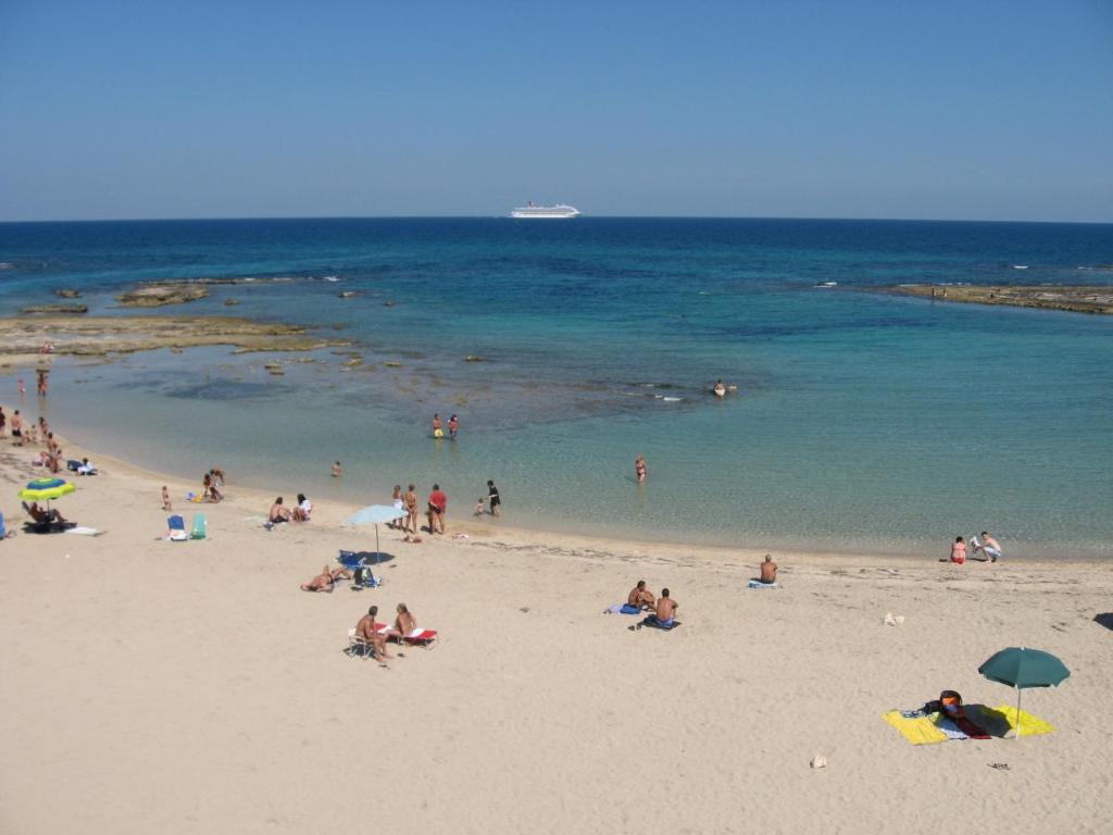 a group of people on a beach with the ocean at Hotel Cicò in Torre Santa Sabina