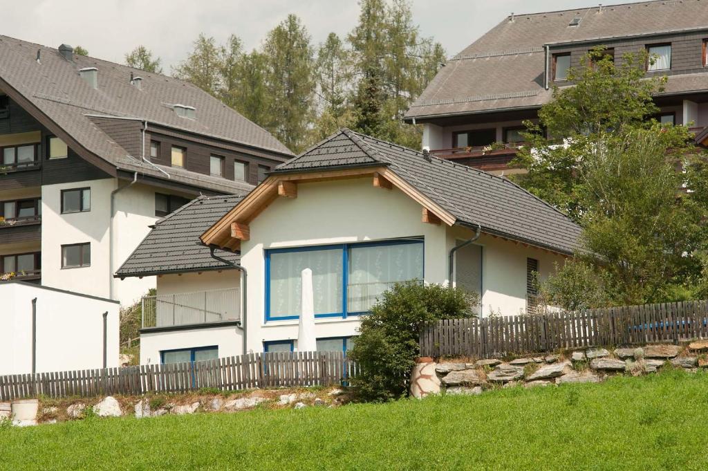 a white house with a black roof and a fence at Haus Sonnenweg in Mariapfarr