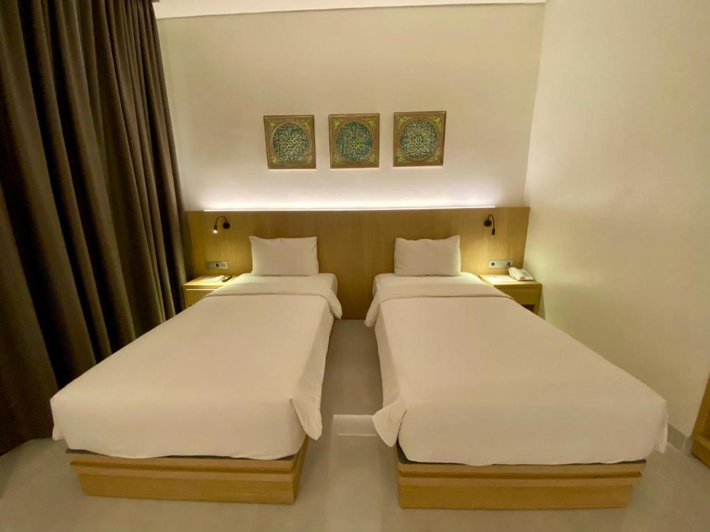 Postel nebo postele na pokoji v ubytování OPI Indah Hotel
