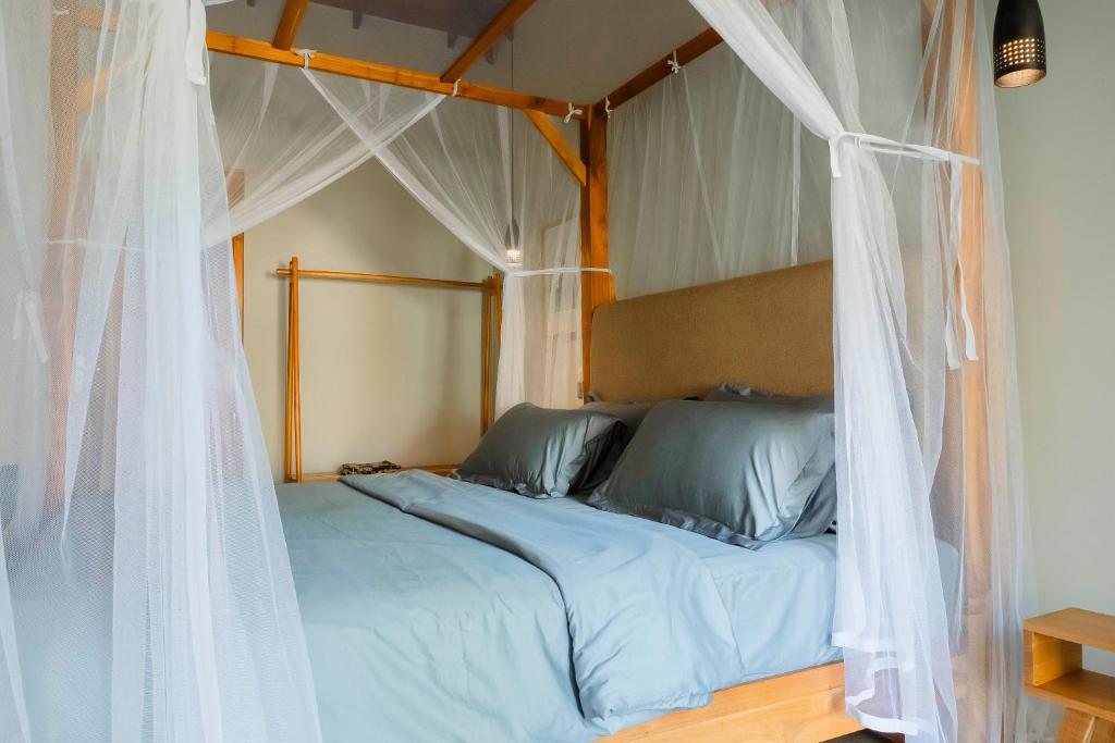 a bed with a canopy with white curtains at The Spice Trail in Arugam Bay