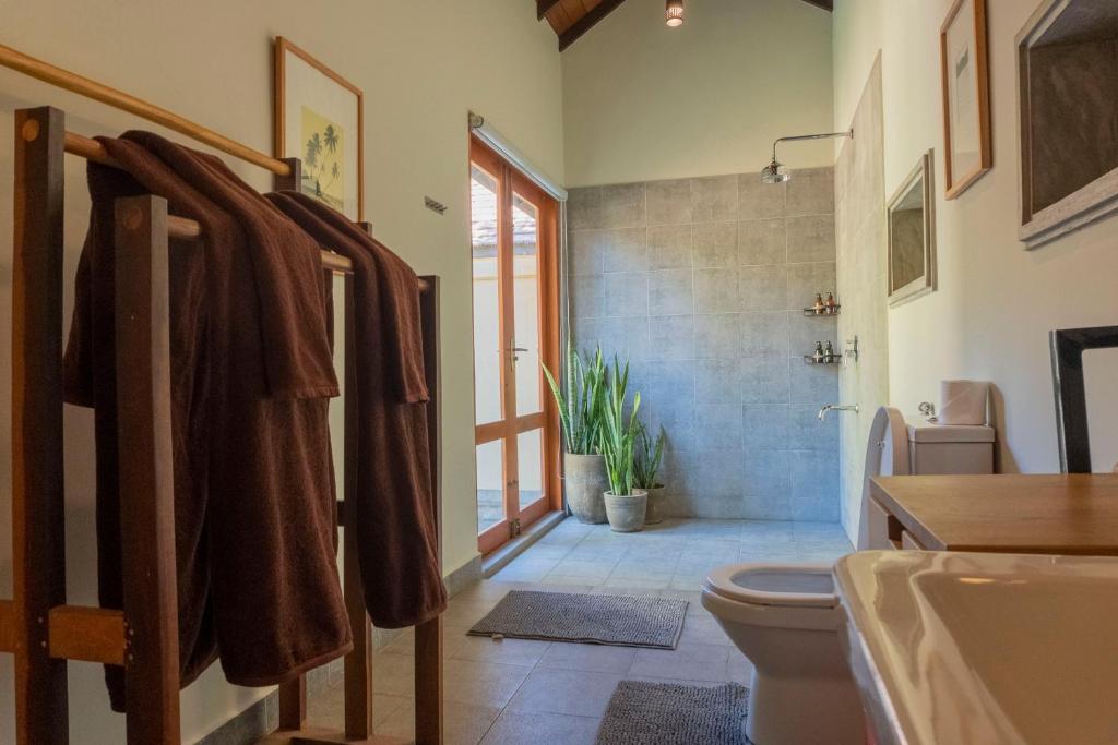 a bathroom with a toilet and a shower and a sink at The Spice Trail in Arugam Bay