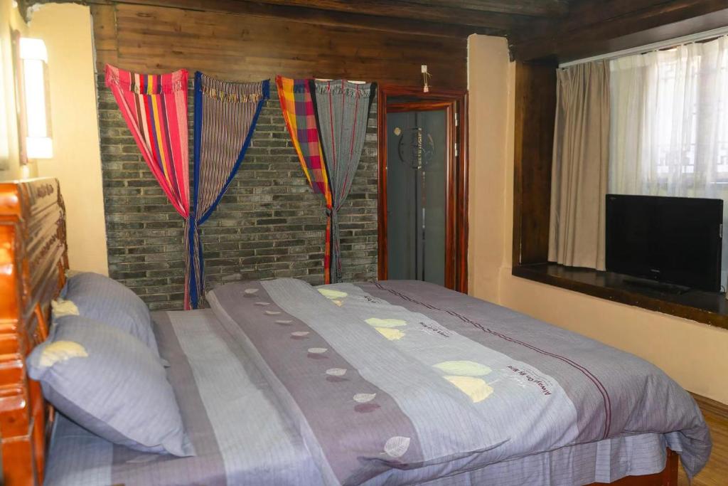 Postel nebo postele na pokoji v ubytování 丽江古城栖旅民宿 qī lǚ lnn old town lijiang