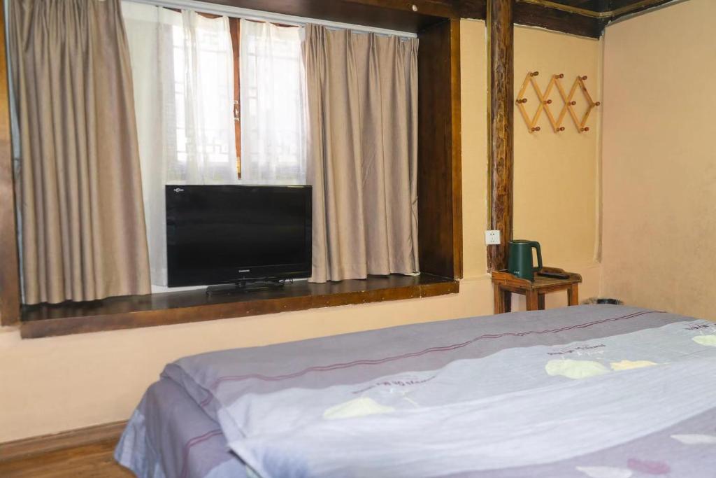 TV a/nebo společenská místnost v ubytování 丽江古城栖旅民宿 qī lǚ lnn old town lijiang