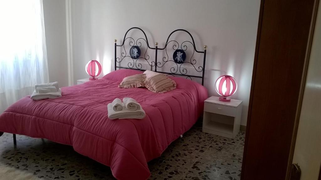 カリアリにあるB&B Argentiera 12のベッドルーム1室(ピンクのランプ2つ、ピンクのベッド1台付)