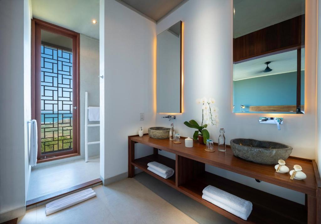 a bathroom with a sink and a mirror at Selong Selo Resort and Residences in Selong Belanak