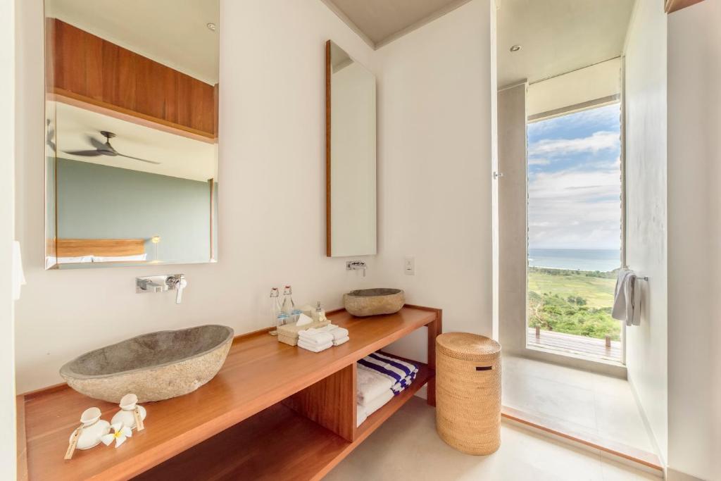 a bathroom with a sink and a window at Selong Selo Resort and Residences in Selong Belanak