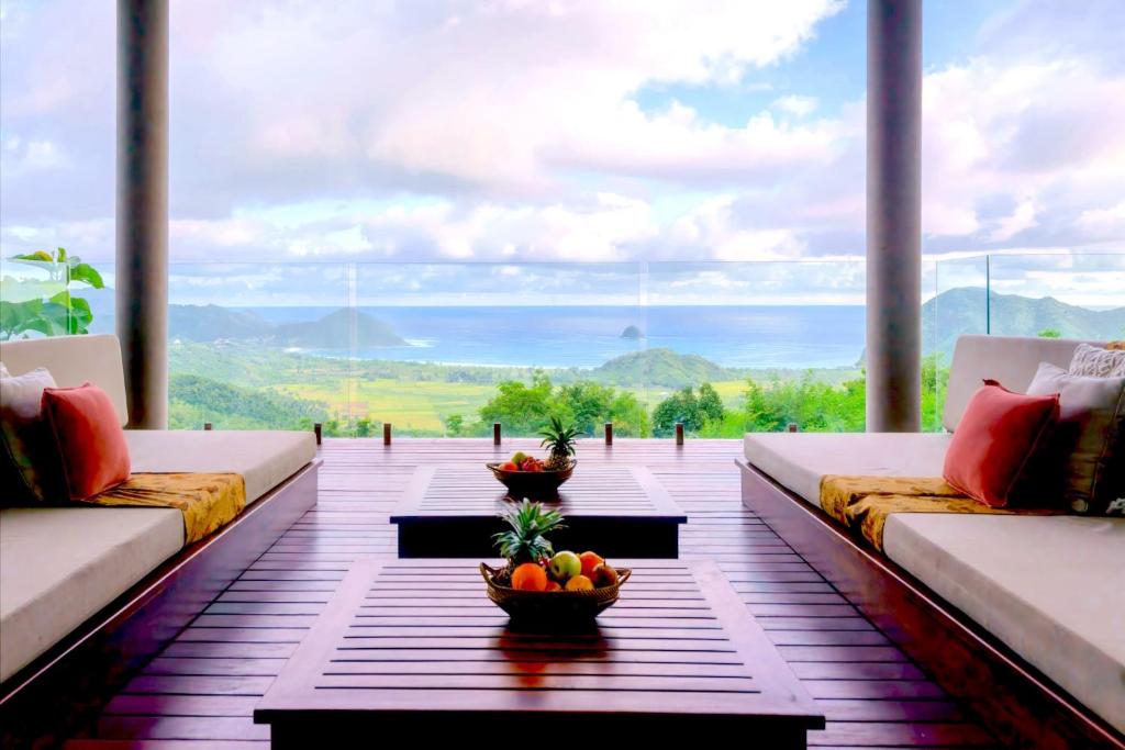a living room with couches and a view of the ocean at Selong Selo Resort and Residences in Selong Belanak