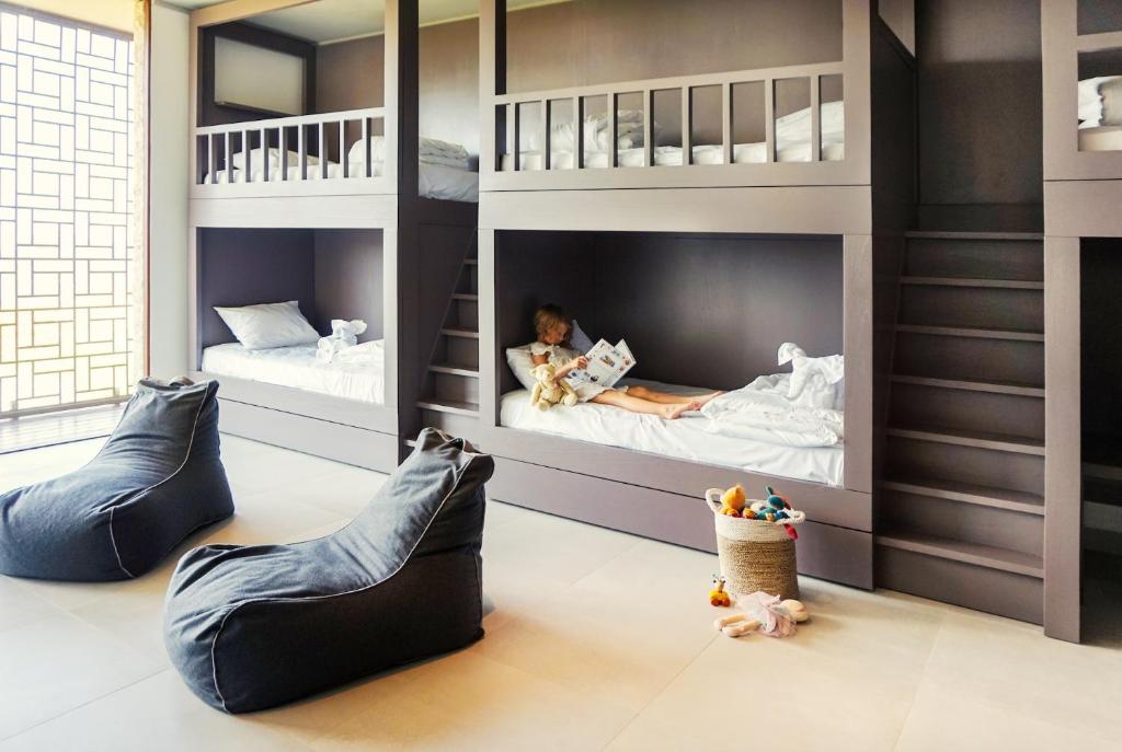a childrens room with two bunk beds and a child laying in them at Selong Selo Resort and Residences in Selong Belanak