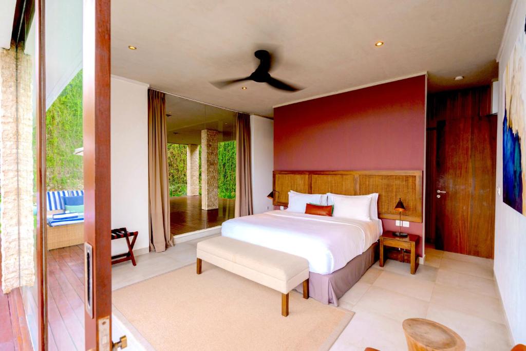 a bedroom with a large bed and a balcony at Selong Selo Resort and Residences in Selong Belanak