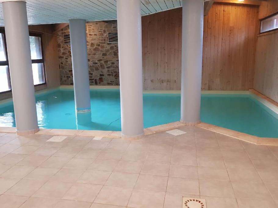 une piscine avec de l'eau bleue dans un immeuble dans l'établissement l été en montagne avec piscine 7 personnes, à Ax-les-Thermes