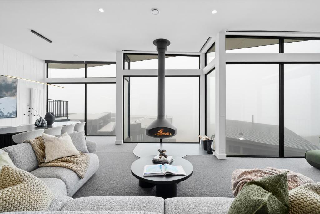 a living room with a couch and a fireplace at Luxury KH Chalet in Mount Hotham